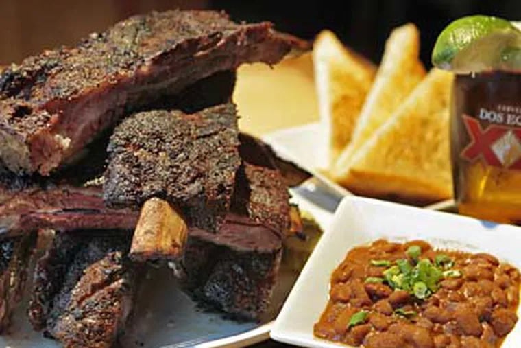 The beef ribs, brontosaurus big and clinging to a twisty char of spice-crusted flesh and fat, are almost a reason in themselves to visit. (Elizabeth Robertson / Staff Photographer)