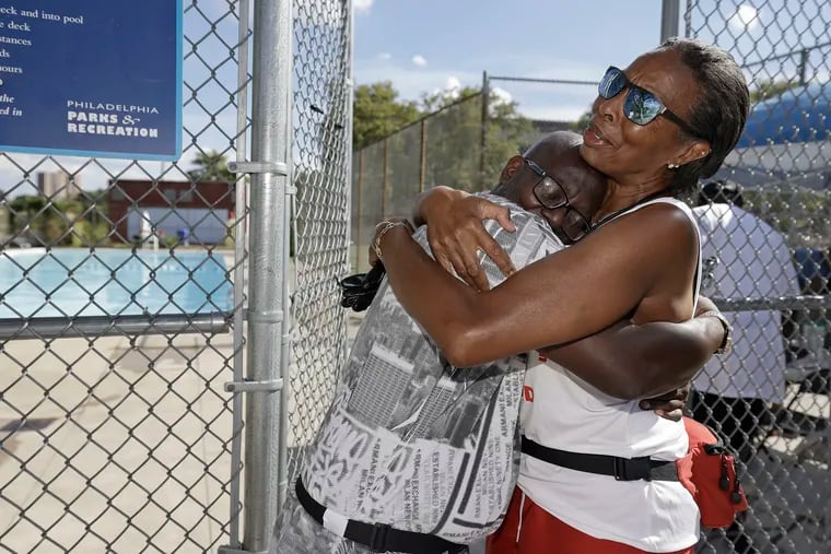 Charles McKnight, a worker at the Mill Creek Recreation Center, embraces Robin Borlandoe as she leaves the center's pool on her last day of work Sunday. The pool closed for the summer on Tuesday.