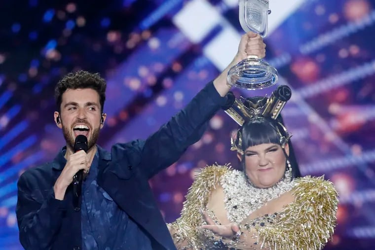 Duncan Laurence of the Netherlands celebrates with the trophy after winning the 2019 Eurovision Song Contest grand final with the song "Arcade" in Tel Aviv, Israel, Saturday, May 18, 2019. In rear is Israeli Netta Barzilai the winner in 2018. (AP Photo/Sebastian Scheiner)