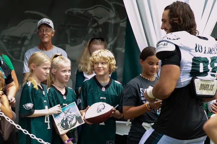 Eagles defensive end Joe Ostman signed autographs for fans at practice Saturday, the day before he injured his knee. He was placed on injured reserve Tuesday morning.