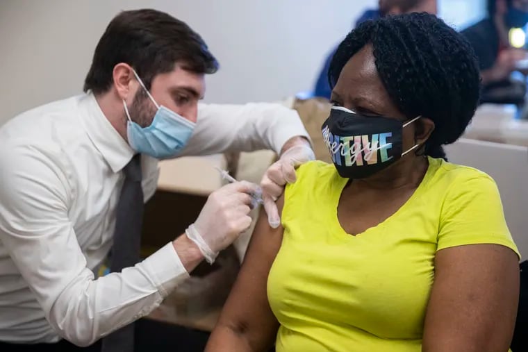Volunteer Scott Jacobs, a pharmacy student at the Philadelphia College of Pharmacy, gives Linda Rodriguez a vaccine during a clinic hosted by State Rep. Jared Solomon and Sunray Pharmacy in Philadelphia on Monday, March 8, 2021.