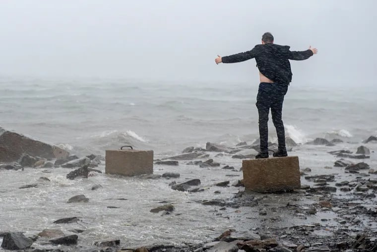 An unidentified man raises his arms in the winds from Hurricane Dorian along the Halifax harbor in Dartmouth, Nova Scotia, Canada, on Saturday, Sept. 7, 2019.