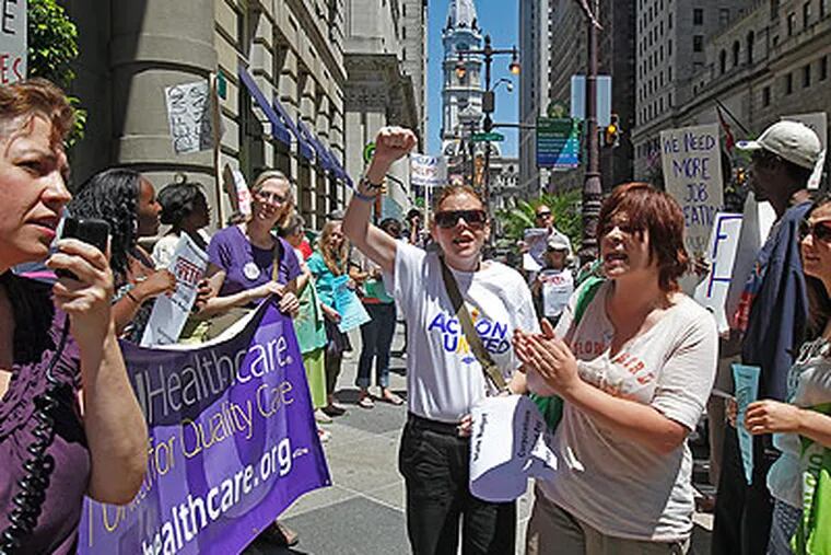 While Kati Sipp, executive vice president for SEIU Healthcare is speaking (left), Cathy Eller from Action United (center with sun glasses) and Rebeca Lovelace (right) chant Friday in front of the Hyatt at Bellevue on Broad Street in Philadelphia. (Akira Suwa / Staff Photographer)