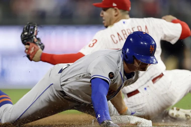 New York's Brandon Nimmo is tagged out by third baseman Asdrubal Cabrera after trying to steal third during the fourth inning of the Phillies' 9-4 loss to the Mets Monday night.