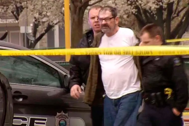 Frazier Glenn Cross, 73, of Aurora, Mo., is led to a police car after his arrest in the shootings at two Jewish centers in Overland Park, Kan. Cross shouted a Nazi slogan at TV cameras as he was taken into custody Sunday.