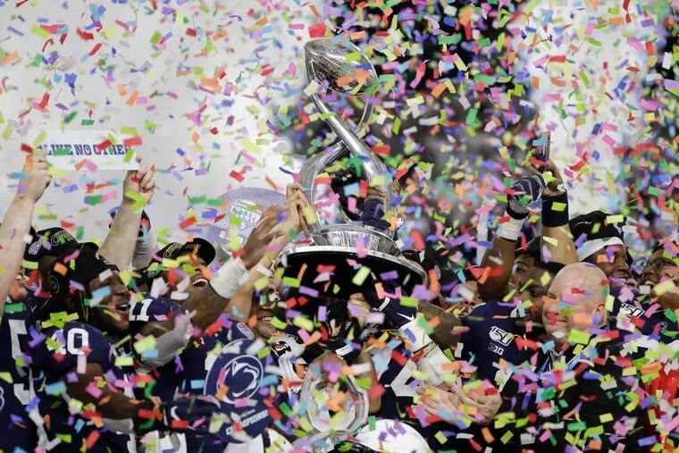 Penn State players hold the Cotton Bowl trophy as confetti falls after beating Memphis 53-39 on Saturday, December 28, 2019 in Arlington, Texas.