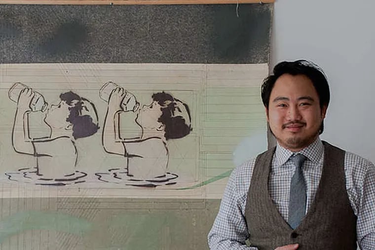 Jason Chen, co-owner of Paradigm Gallery, with one of the exhibit's artworks, "Thirsty Boys," by the artist Mando. (Victoria Mier/The Inquirer)