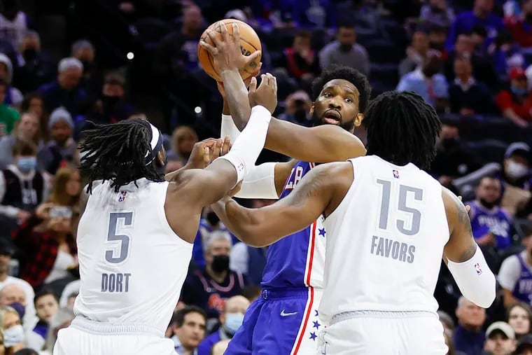 Sixers center Joel Embiid gets double teamed by Oklahoma City's Luguentz Dort and Derrick Favors in the first quarter on Friday night's game at the Wells Fargo Center.