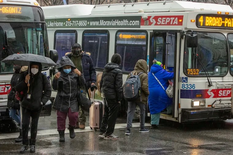 Commuters exit and enter SEPTA buses at North 15th and Market Streets on a wet January morning.