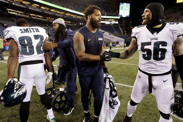 Seattle Seahawks Richard Sherman, second left, and Michael Bennett greet Philadelphia Eagles Torrey Smith (82) and Chris Long after an NFL football game, Sunday, Dec. 3, 2017, in Seattle.