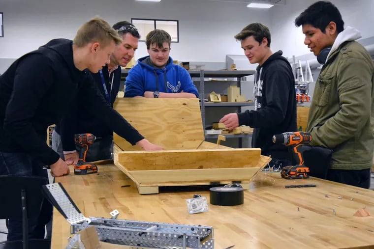 Bensalem High School Engineering Teacher Daniel Lubacz,2nd from L, with Industrial Design Class students (L-R) Jakub Hajduk,Eric Rosenberg, Michael Wible and Brandon Gomez work on the low-fidelity prototype of their sled for the blind.  March 25,2018.