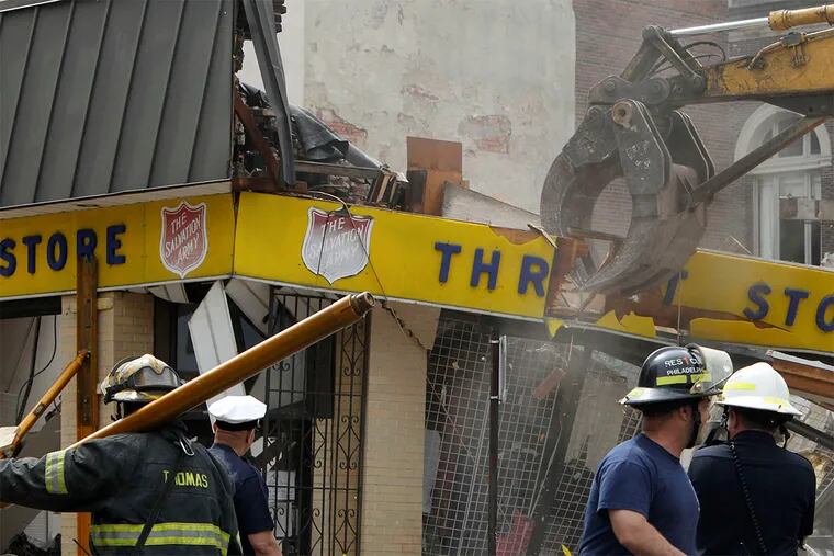 Workers remove the remnants of the Salvation Army store at 22d and Market Streets after a neighboring four-story building collapsed, killing six people and injuring 13 in 2013.