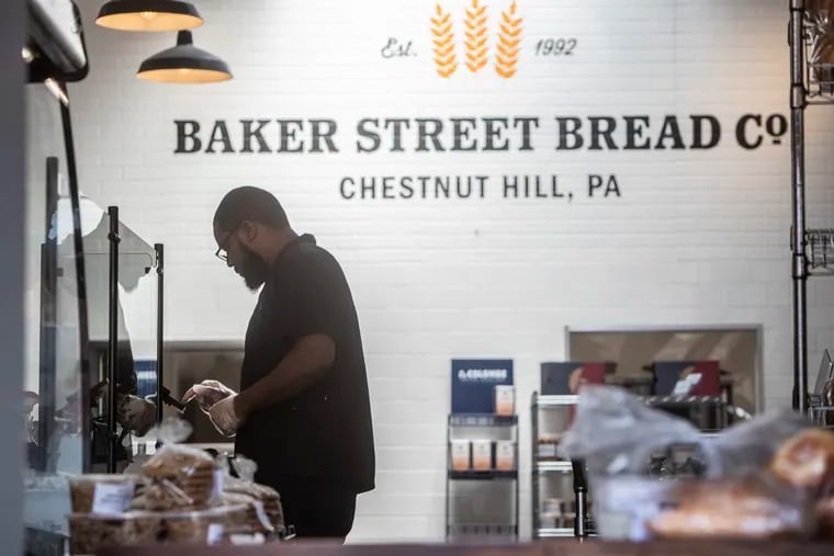 Steve Halstead, an employee of the Baker Street Bread Co. in Chestnut Hill, rings up the order for a customer that was picking up bread.