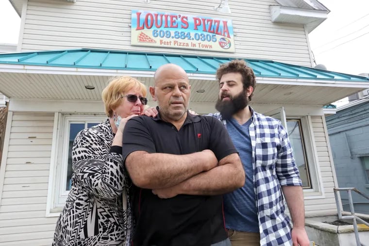 Mohamed Abdelsalam, center, son, Yoseph,and wife, Lisa, outside the closed Louie’s Pizza, in Cape May,  Wednesday, April 22, 2021.
