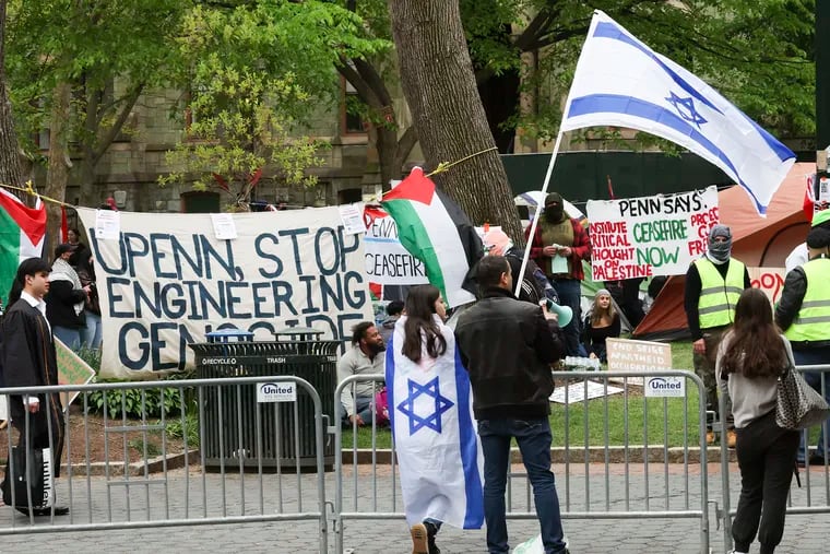 Counter-protestors in support of Israel stand across from the encampment in support of Palestine at College Green on the campus of Penn in Philadelphia on Saturday. The Penn protesters are calling for the university to disclose its financial holdings, divest from any investments in the war, and provide amnesty for pro-Palestinian students facing discipline over past protests.