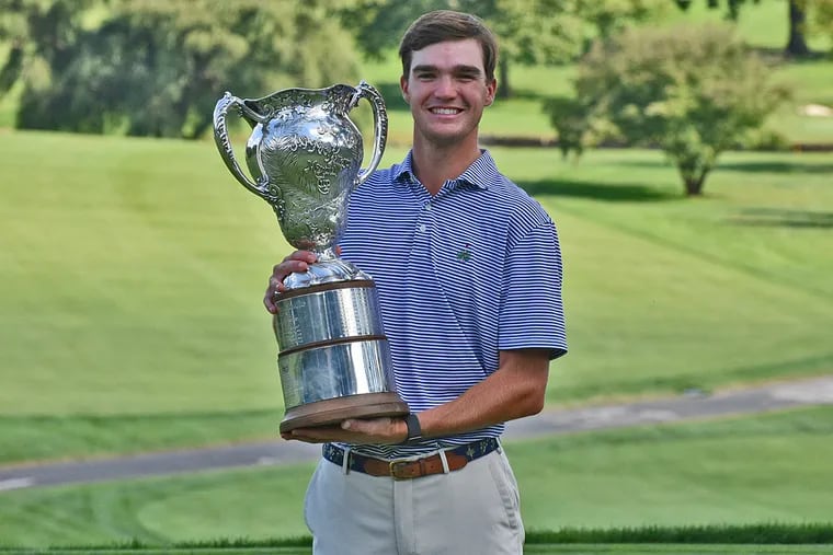 2021 Patterson Cup champion Peter Bradbeer holds the winner's trophy.