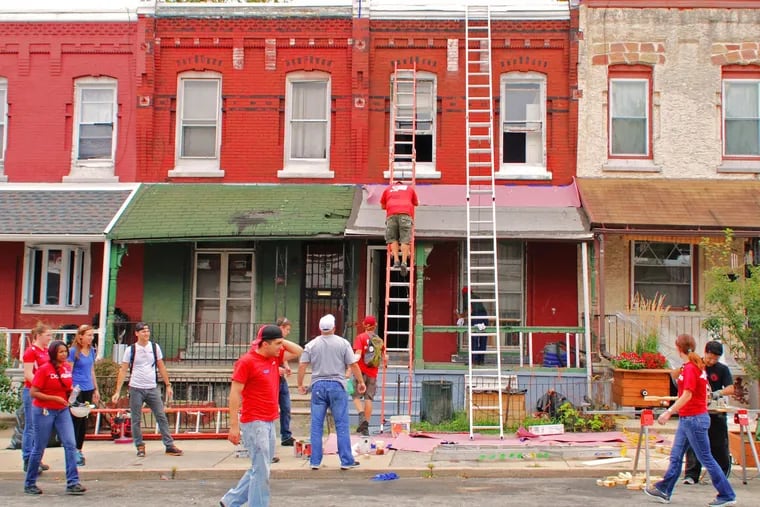 Habitat for Humanity staff and volunteers complete exterior repairs on an owner-occupied home in Philadelphia in 2014. The total cost of the home repairs needed across the Philadelphia metro area in 2022 was at least $3.7 billion, according to a report by the Philadelphia Fed.