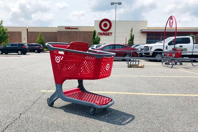 In this June 3, 2019, file photo a shopping cart sits in the parking lot of a Target store in Marlborough, Mass.  (AP Photo/Bill Sikes, File)