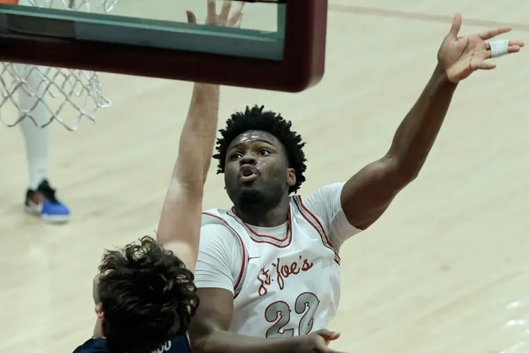 Christ Essandoko shoots during his debut for St. Joseph's on Friday night against Penn. The 7-foot freshman finished with nine points and 10 rebounds.