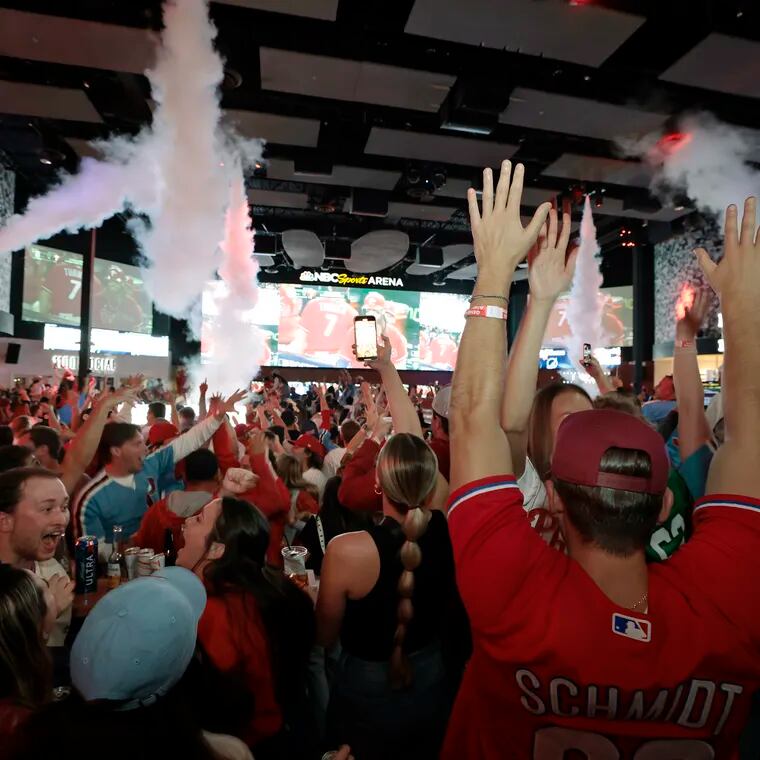 Phillies fans at Xfinity Live! celebrate during a Phillies NLCS game in the fall.