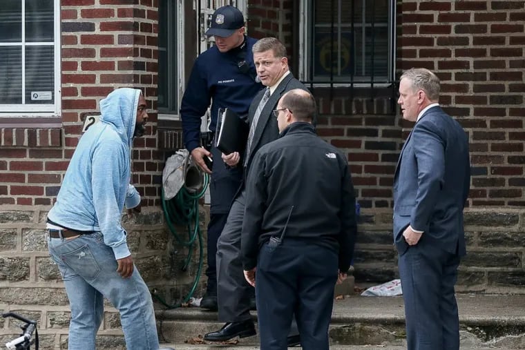Philadelphia Police Department detectives talk to a passerby after a 2-year-old was found with a gunshot wound to the head in the basement of a home in the 200 block of West Godfrey Avenue in Olney on Thursday, Nov. 9, 2017.