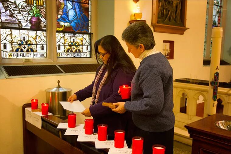 Fifty murder victims are remembered in a 48 hour vigil at the Cathederal of the Immaculate Conception in Camden over the past weekend. Here at the 9 a.m. Sunday Mass, parishioner Elva Vazquez, left and Sister Helen Cole with candles lit in the memory of those killed in Camden this year. (ED HILLE/Staff Photographer)