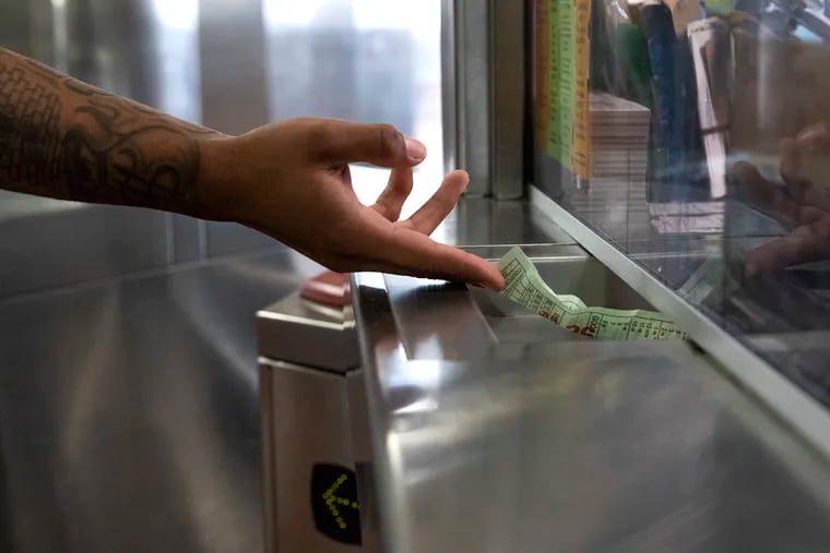 A commuter hands their paper transfer slip to  a cashier at the 69th Street Transportation Center in Upper Darby, on Thursday, July 26, 2018.