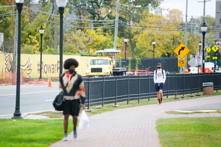 Students walk while wearing masks and practicing social distances at Rowan University in Glassboro, NJ, on Friday. Glassboro has seen a surge of Coronavirus cases mainly driven by the area's student population.
