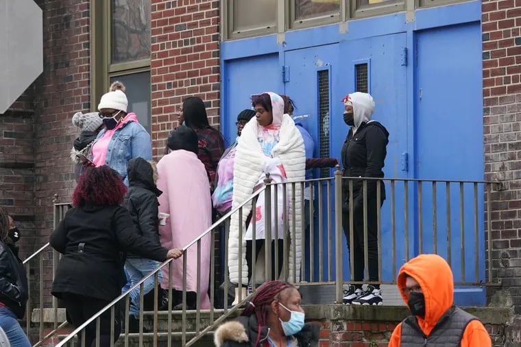 People gathered at Bache-Martin Elementary School after a fatal fire in the Fairmount section of Philadelphia, on Wednesday, Jan. 5, 2022.