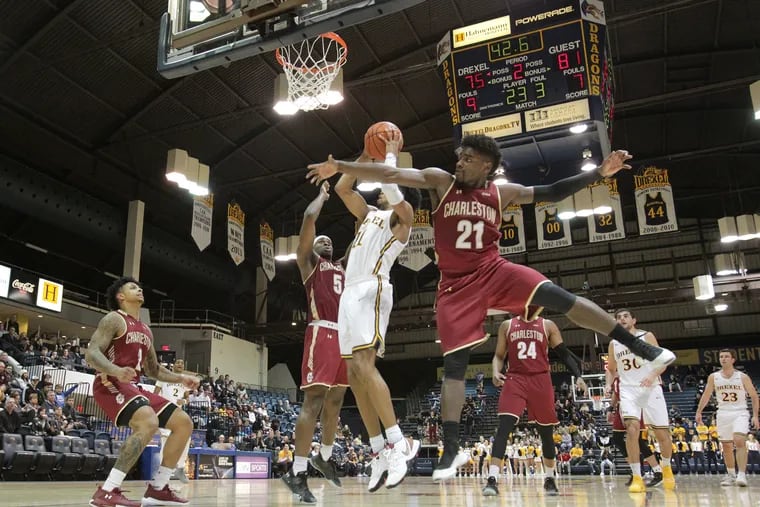 Drexel's Camren Wynter (center) puts up a shot against College of Charleston's Jarrell Brantly (left) and Marquise Pointer during a Feb. 9 game in Philadelphia. The Dragons lost Sunday in the quarterfinals of the CAA tournament.