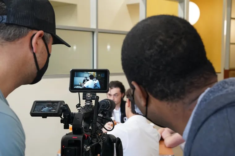 Director of photography Greg Lassik (left) and writer and director Andre Joseph walk through a scene on the set of “Dismissal Time” with several local extras at the Bucks County Technology Park in Trevose earlier this month.