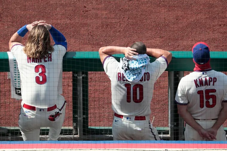 (L-R) Phils Bryce Harper, J.T. Realmutto and Andrew Knapp watch from the dugout as the Phils bat late in game during the Philadelphia Phillies vs. the Miami Marlins Major League baseball game at Citizens Bank Park on Sunday.