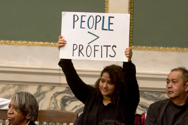 Tiffany Rodriguez, a youth advocate, holds a sign during a City Council hearing on tobacco retail regulations in Philadelphia.