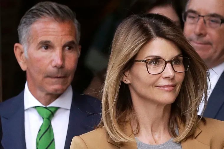 In this April 3 photo, actress Lori Loughlin, front, and her husband, clothing designer Mossimo Giannulli, left, depart federal court in Boston after a hearing in a nationwide college admissions bribery scandal.