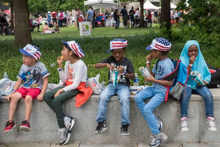 Youngsters in Independence Mall eat their free meals at Wawa's Hoagie Day Thursday, June 28, 2018, part of the Welcome America July Fourth festivities.