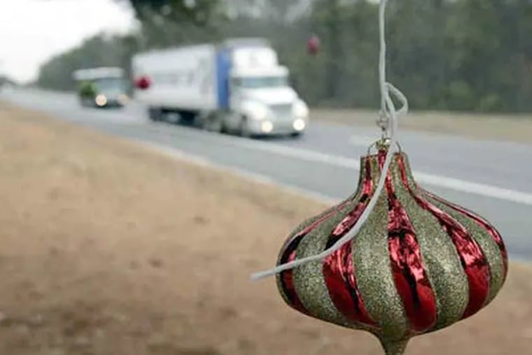 Christmas decorations hang from a tree near Mile Marker 58.2 in this 2007 photo. The tradition continues. (Mel Evans / AP, File)