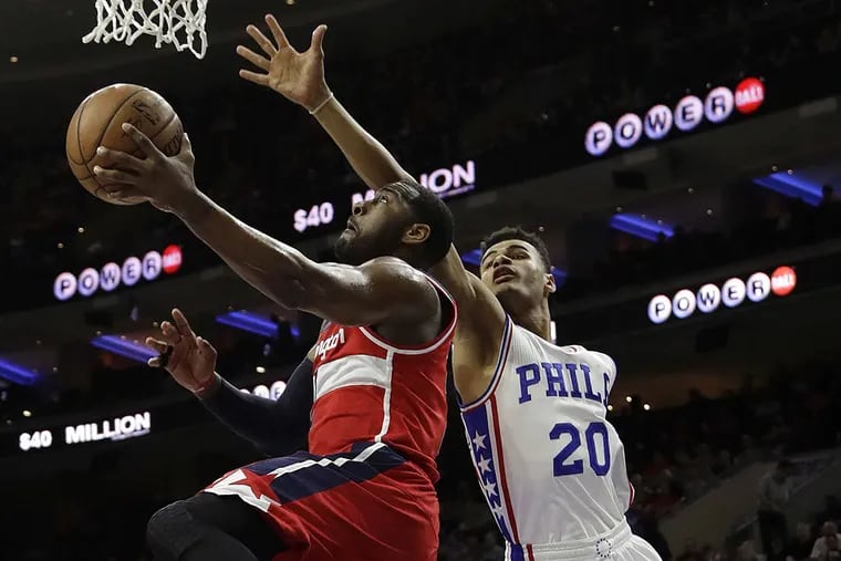 Washington Wizards’ John Wall, left, goes up to shoot against Philadelphia 76ers’ Timothe Luwawu-Cabarrot during the first half of an NBA basketball game, Friday, Feb. 24, 2017, in Philadelphia.