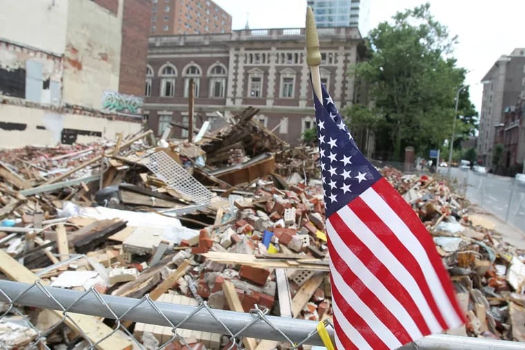 The site of the building collapse at 22nd and Market streets in Philadelphia is shown on June 13, 2013.  Everything has now been leveled and is fenced off.  Flags, flowers and other memorial items have been placed on or near the fence.