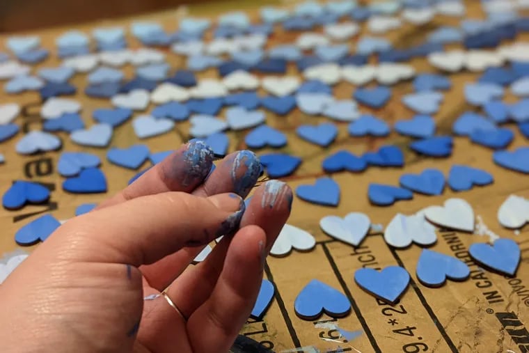 Casey Bien-Aime, spiritual care coordinator at Lankenau Medical Center, painted 296 wood hearts in shades of blue to represent Lankenau patients who died of COVID-19 between March 10, 2020 and March 10, 2021. She said it helped her cope with her own grief.