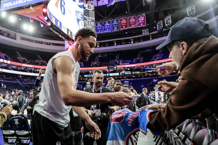 Brooklyn Nets forward Ben Simmons signs an autograph for a Nets fan before his game against the Sixers at the Wells Fargo Center in Philadelphia, Tuesday,  November 22, 2022.