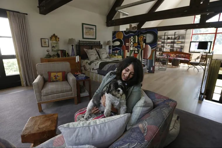 Hannah Dee, with her dog, Lumi, in the multipurpose loft space inside her Chestnut Hill house.