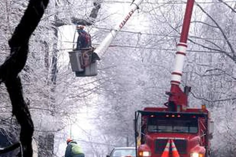 Casey Daniels, in bucket, and Nick Sousa cut branches over power lines in Massachusetts after Thursday&#0039;s ice storm.