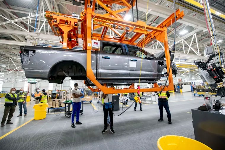 Ford employees assemble the Ford F-150 Lightning at the Ford Rouge Electric Vehicle Center in Dearborn, Mich.