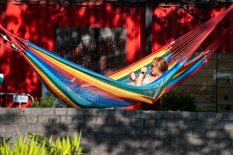 Brittany Greigg, lounges on a hammock on Wednesday, May 18, 2022., at Spruce Street Harbor Park in Philadelphia, Pa.