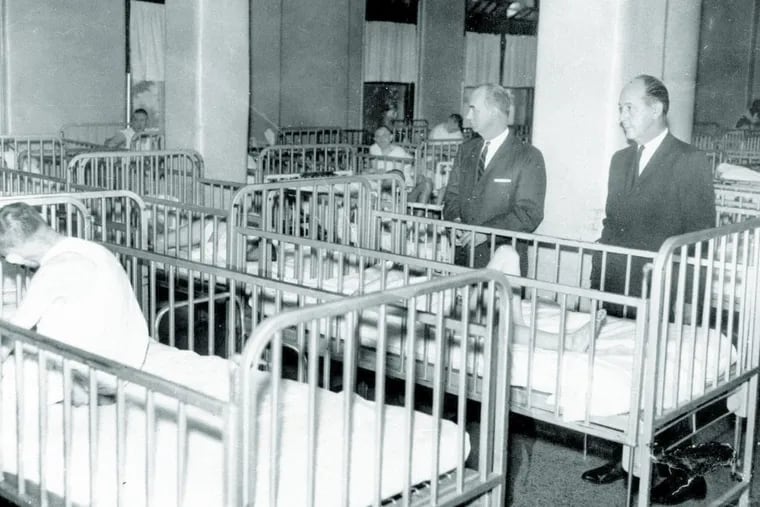 Adult patients at the Pennhurst State School and hospital spent their days and nights in cribs. The school superintendent, Dr. Leopold A. Potkonski, left, and State Rep. Edwin G. Holl, chairman of the Montgomery County delegation, toured the ward Nov. 16, 1965.