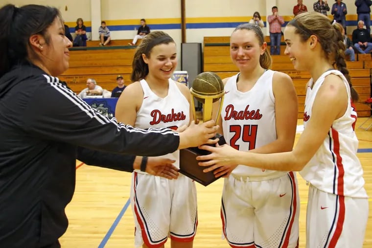 Jenkintown senior tricaptains (from left) Jennifer Kremp, Amelia Mulvaney and Ashley Kremp accept the Bicentennial Athletic League basketball  championship trophy from Morrisville coach Tanya Argueta.