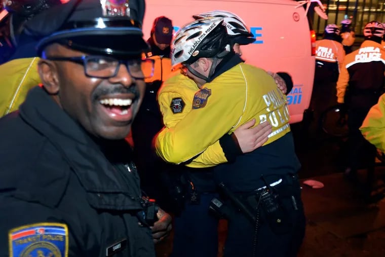 Overjoyed Philadelphia police officers embrace  near the Temple University campus along Broad St and Cecil B. Moore Ave at the conclusion of the Eagles Super Bowl victory on Sunday.