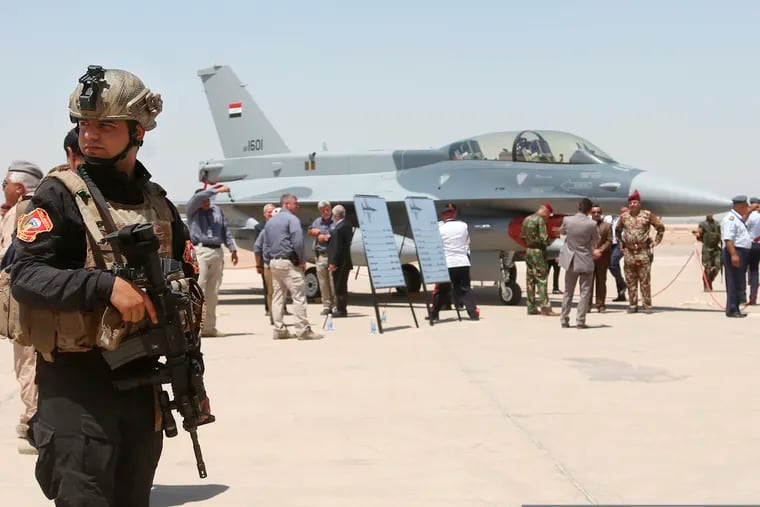 In this Monday, July 20, 2015 file photo, a member of the Iraqi SWAT team stands guard as security forces and others gather next to a U.S.- made F-16 fighter jet during the delivery ceremony at Balad air base, Iraq. Security measures have been increased at one of the country’s largest air bases that houses American trainers, following an attack last week, a top Iraqi air force commander said Saturday, June 22, 2019 while the U.S. military said operations at the base are going on as usual and there are no plans to evacuate personnel at the present time.