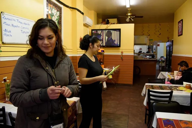 Soda tax outreach team member Keinalyse Medina-Morales leaves after giving informational material to Alejandra Mendez (right) at the El Compadre restaurant.