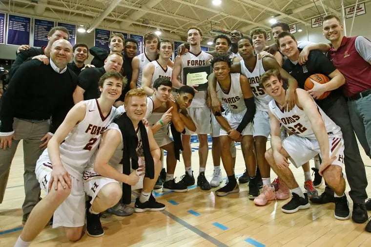 With Christian Ray holding the plaque, Haverford School players and coaches pose for photos after the PAISAA boys' basketball championship Saturday, Feb. 23, 2019, at Jefferson University. The Fords defeated Westtown in the final, 67-62, in overtime. LOU RABITO / Staff